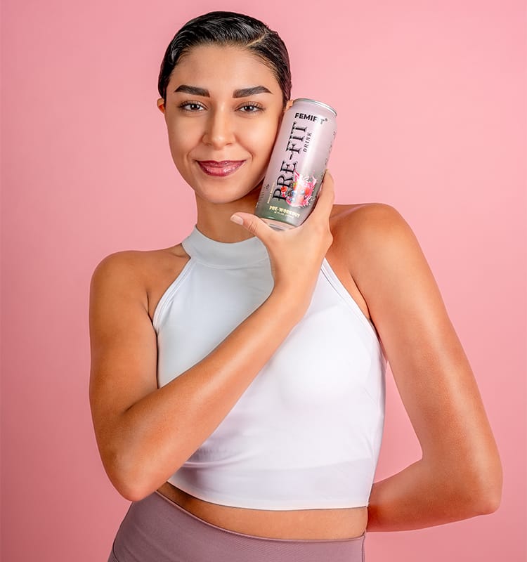 a lady holding a can of pre-fit pre-workout drink.